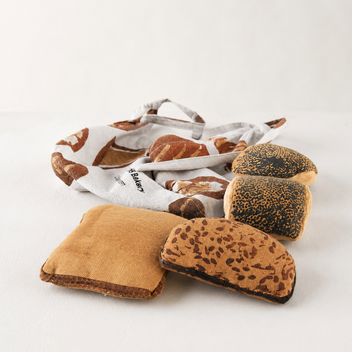 Plush bread toys with a bakery-themed bag on a light background