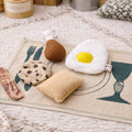 Handmade fabric breakfast play food with egg, bacon, cookie, pear and pillow on a printed play mat