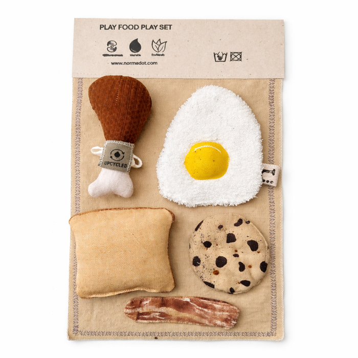Handmade fabric play food set with egg, drumstick, toast, cookie and bacon on a cotton play mat