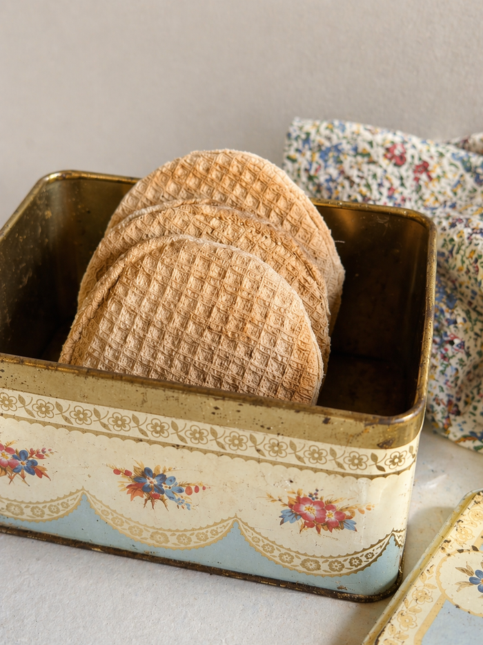 Handmade fabric stroopwafels displayed in a vintage tin with soft bakery play food in the background.