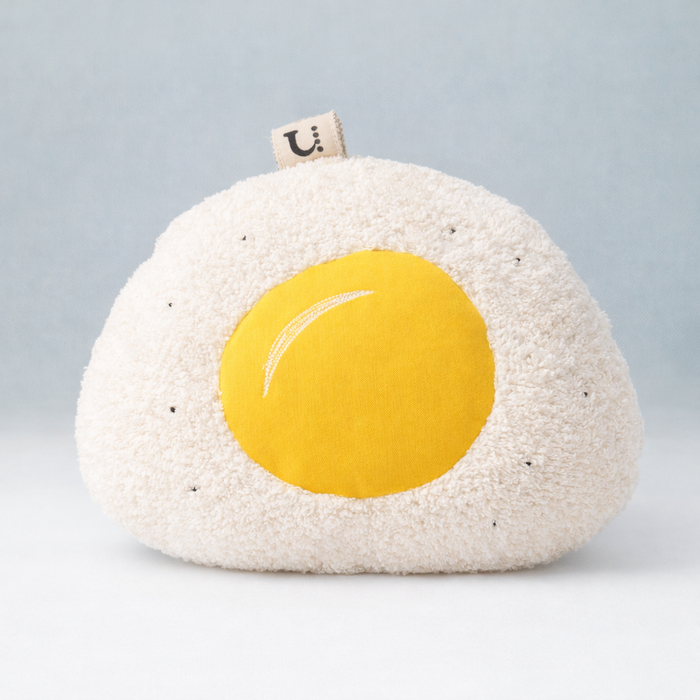 Handmade Round Terry cloth fried egg pillow on a light gray background