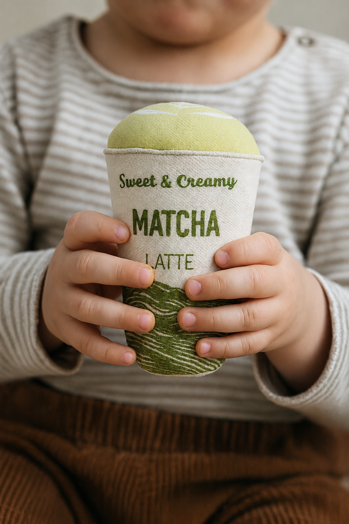 Handmade textile matcha latte plush toy held by a child, with soft fabric cup and green latte top for pretend café play.