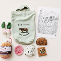 Handmade soft deli grocery play set with fabric pancetta, radishes, bread, blue cheese, seed cracker, cotton tote bag and cow colouring sheet on a light background.