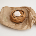 Handmade Danish kanelsnegl fabric play food with velour icing, displayed on recycled brown paper.