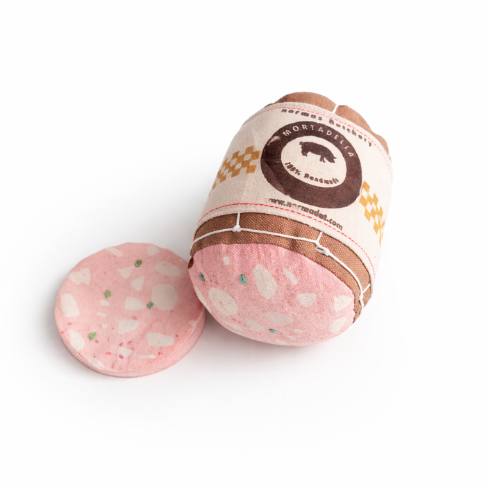 Handmade fabric mortadella play food toy with one soft slice, cotton label and stitched details on a white studio background.