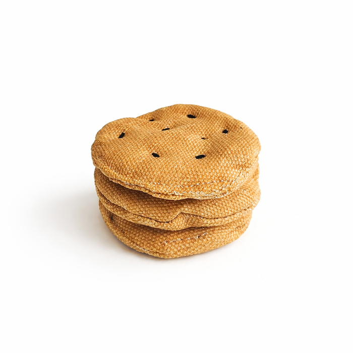 Handmade fabric crispbread play food, stacked with embroidered seed details on a clean white background.