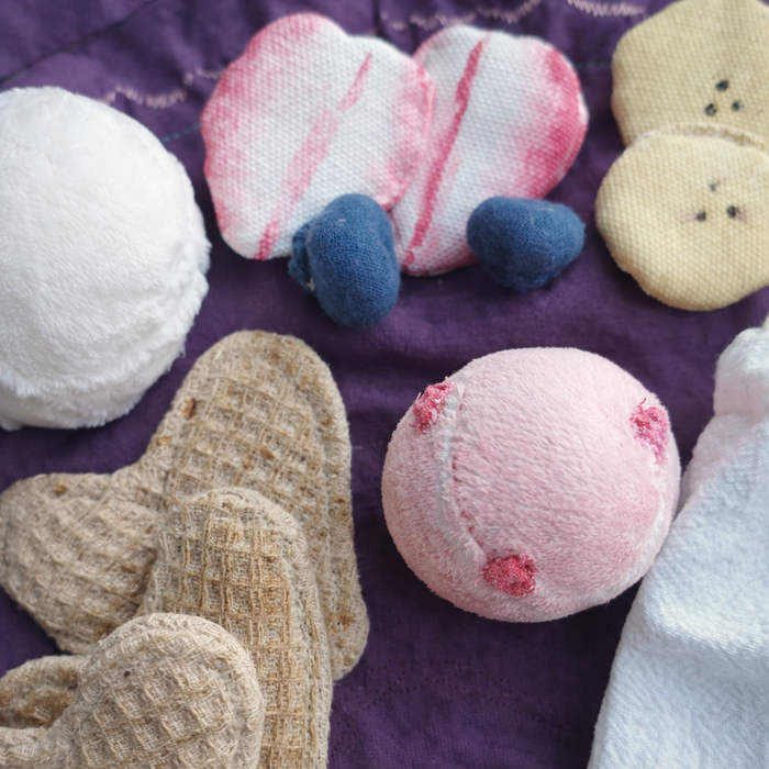 Collection of handmade fabric waffles fruit and toys on a purple fabric background